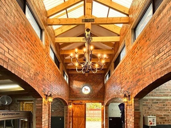Hall interior with exposed timber roof trusses and chandelier