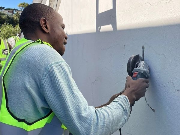 Painter preparing a wall surface before painting