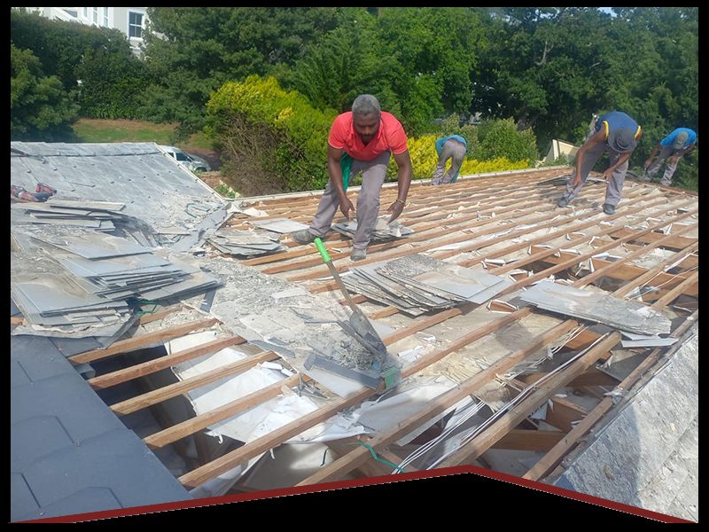 Rome Roofing team stripping an existing roof cover during a reroofing project